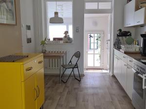 a kitchen with a yellow refrigerator and a chair in it at Ferienwohnung Havelnixe in Bahnitz