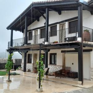 a large house with a balcony and a table at Vegas de la Alcarria in Horche