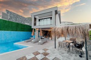 a villa with a swimming pool and a house at Fortunella Villas in Finike