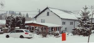 ein weißes Auto im Schnee vor einem Haus geparkt in der Unterkunft Casa ANSI 