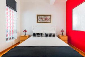 - une chambre avec un grand lit et un mur rouge dans l'établissement Douradores Downtown Flat, à Lisbonne