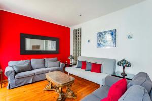 - un salon avec deux canapés et un mur rouge dans l'établissement Douradores Downtown Flat, à Lisbonne