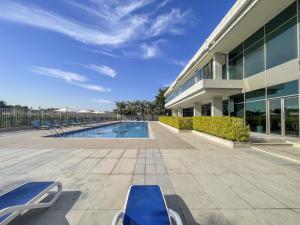 a large building with a swimming pool next to a building at Trinity Holiday Homes - Polo Residences Meydan in Dubai