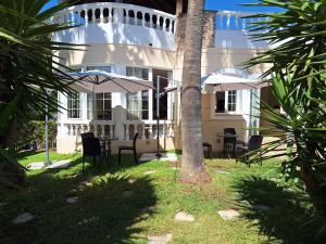 a building with chairs and umbrellas in front of it at Perla Beach in Agia Marina Nea Kydonias