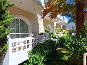 a white fence in front of a house at Perla Beach in Agia Marina Nea Kydonias