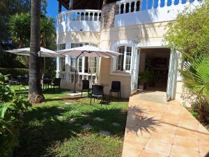 a house with two umbrellas and a table and chairs at Perla Beach in Agia Marina Nea Kydonias