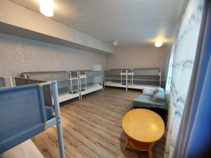 IlomantsiにあるHotel Ilomantsi North Starの二段ベッド、テーブル、ソファが備わる客室です。