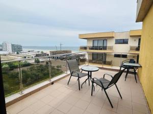 einen Balkon mit Stühlen, einem Tisch und Meerblick in der Unterkunft Apartament vedere la mare in Mamaia