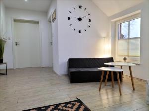 a living room with a couch and a clock on the wall at Ferienwohnung Auszeit 65354 in Moormerland