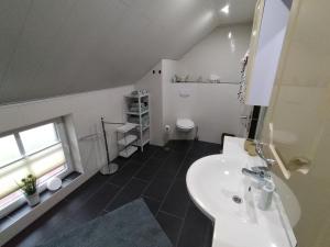 a bathroom with a white sink and a toilet at Ferienwohnung Auszeit 65354 in Moormerland