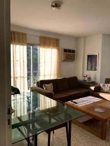 a living room with a couch and a glass table at Departamento amoblado en Asunción - Paraguay in Asuncion