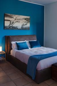 ein Schlafzimmer mit einem großen Bett mit blauen Wänden in der Unterkunft La Dolce Vita in Regalbuto