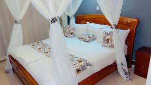 a bedroom with a bed with white sheets and pillows at Victoria Rock Resort in Entebbe