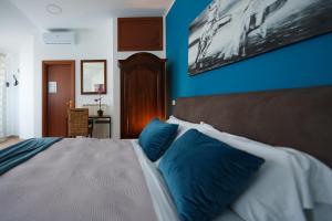 Schlafzimmer mit blauen Wänden und einem Bett mit blauen Kissen in der Unterkunft La Dolce Vita in Regalbuto