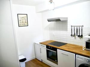 a kitchen with white walls and a stove top oven at La Perle - Montargis in Montargis
