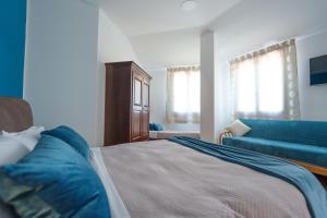 1 dormitorio con 1 cama y 1 sofá azul en La Dolce Vita, en Regalbuto