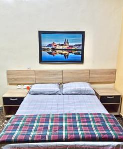 1 dormitorio con 1 cama y TV en la pared en Bravo Apartment, Awka, en Akwa