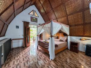 ein Schlafzimmer mit einem Himmelbett in einem Gebäude in der Unterkunft Sumatra Orangutan Treks Villa in Timbanglawang