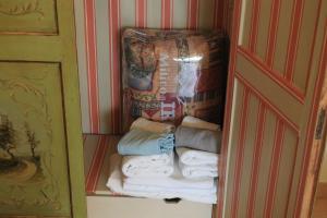 a closet with a stack of towels and a box at La Stanza Nova in Foiano della Chiana