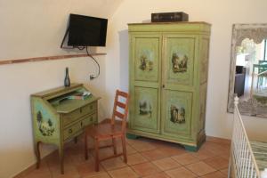 a room with a green cabinet and a desk and a chair at La Stanza Nova in Foiano della Chiana