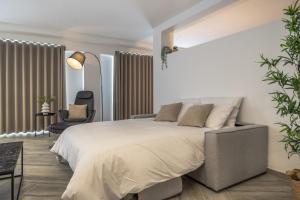 Un dormitorio con una cama grande y una silla. en The Cube - Designer finished studio by SF Homes, en Il-Gżira