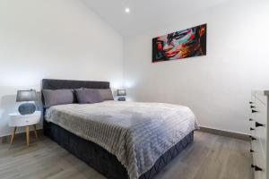 - une chambre avec un lit et une photo sur le mur dans l'établissement rentafive Vistas al mar Chalet 2 Terrazas, à Santa Pola