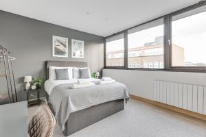 a bedroom with a large bed and large windows at Spacious 1 BR apt w 2 king bed by Tent serviced apartments in Farnborough
