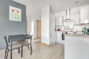 uma cozinha com uma mesa e uma sala de jantar em Spacious 1 BR apt w 2 king bed by Tent serviced apartments em Farnborough