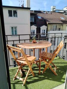 un tavolo in legno e 2 sedie sul balcone di hyper centre a Montreux