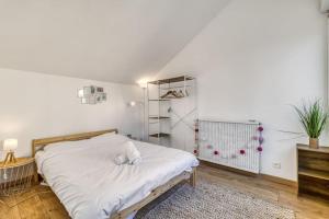 ein Schlafzimmer mit einem weißen Bett und einem Regal in der Unterkunft ZenBNB / Medini / Parking / 4 pers. / WiFi / in Annemasse