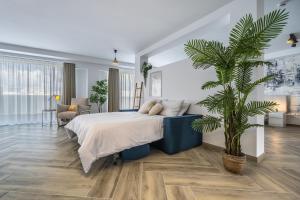 een slaapkamer met een groot bed en een palmboom bij Luxury & comfort awaits at this studio apartment! in Il-Gżira