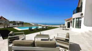 a patio with a couch and a table and the ocean at Casa da Luísa in Lourinhã