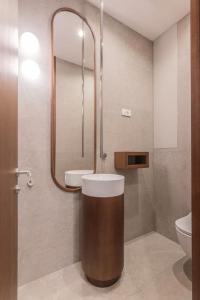 ein Badezimmer mit einem WC, einem Waschbecken und einem Spiegel in der Unterkunft City Centre Design Apartment in Split