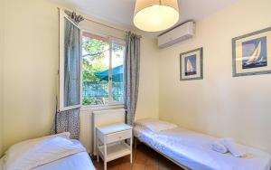 um quarto com duas camas e uma janela em Beautiful Air-Con House 5min from the Beaches em Cannes