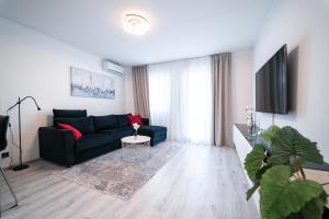 a living room with a blue couch and a tv at Luxury Apartment in Peaceful Neighborhood Split in Solin