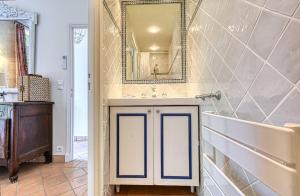 a bathroom with a sink and a tub and a mirror at Beautiful Air-Con House 5min from the Beaches in Cannes