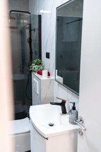 a white bathroom with a sink and a mirror at Luxury Apartment in Peaceful Neighborhood Split in Solin