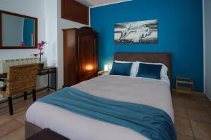 ein Schlafzimmer mit einem großen Bett mit blauen Wänden in der Unterkunft La Dolce Vita in Regalbuto