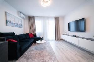 a living room with a black couch and a flat screen tv at Luxury Apartment in Peaceful Neighborhood Split in Solin