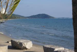una spiaggia con due grandi rocce in acqua di Sammy Seaview Mae Ramphueng Beach Frontบ้านช้างทองวิวทะเลหน้าหาดแม่รำพึง a Rayong