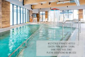a large indoor pool with a water fountain at HOLIDAY HOME Bel Mare 109b z tarasem i ogródkiem in Międzyzdroje