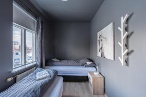 ein kleines Schlafzimmer mit 2 Betten und einem Fenster in der Unterkunft Day Dream Strandgata 11 in Akureyri