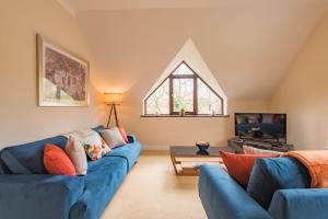 ein Wohnzimmer mit blauen Sofas und einem Fenster in der Unterkunft Honeywood Lodge by Bloom Stays in Canterbury