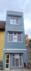 a blue building with four windows on the side of it at Pleasant Stay B&B in Amritsar