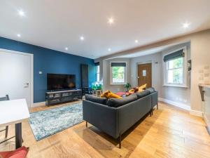a living room with a couch and a television at Comfy Apartment With Garden in Surbiton in Surbiton