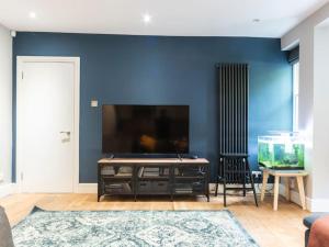 - un salon avec une télévision et un aquarium dans l'établissement Surbiton Garden Flat, à Surbiton