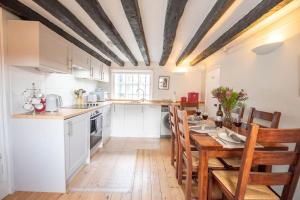 a kitchen with a wooden table and a dining room at Vela Art Gallery - Holiday Apartment in Saxmundham