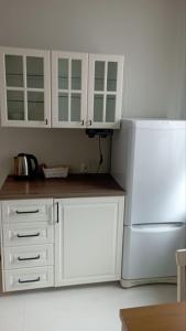 een keuken met witte kasten en een witte koelkast bij UrbannestApartments/Lip2/7 in Katowice