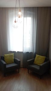 een woonkamer met 2 stoelen en een raam bij UrbannestApartments/Lip2/7 in Katowice