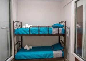 two bunk beds in a room with blue sheets at A Casa D'Irene in Perea